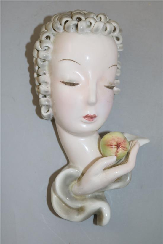 A Goldscheider mask of a lady holding a fruit, 8in.